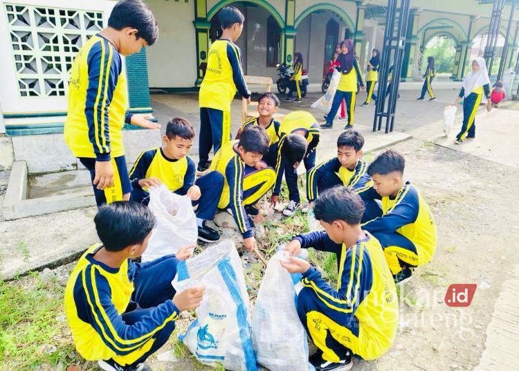 Para siswa saat mengikuti kerja bakti membersihkan jalan desa dan sekitar sekolah serta memilah sampah, Jumat (21/2). (Unggul Priambodo/Lingkarjateng.id)