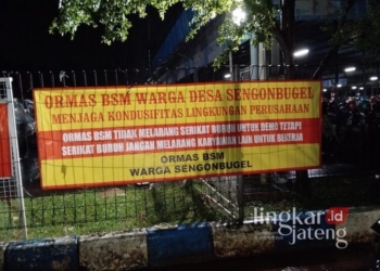 Pemasangan banner oleh ormas Barisan Satria Muda (BSM) di salah satu pabrik di Kecamatan Mayong, Kabupaten Jepara. (Tomi Budianto/Lingkarjateng.id)