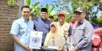 SIMBOLIS: Bupati Jepara, Witiarso Utomo (kiri), didampingi Wakil Bupati Jepara, M. Ibnu Hajar (berpeci) menyerahkan bantuan kepada Mbah Darwati (75) warga Desa Klepu, Kecamatan Keling, Kabupaten Jepara, yang rumahnya roboh akibat hujan angin, pada Minggu, 2 Maret 2025. (Tomi Budianto/Lingkarjateng.id)