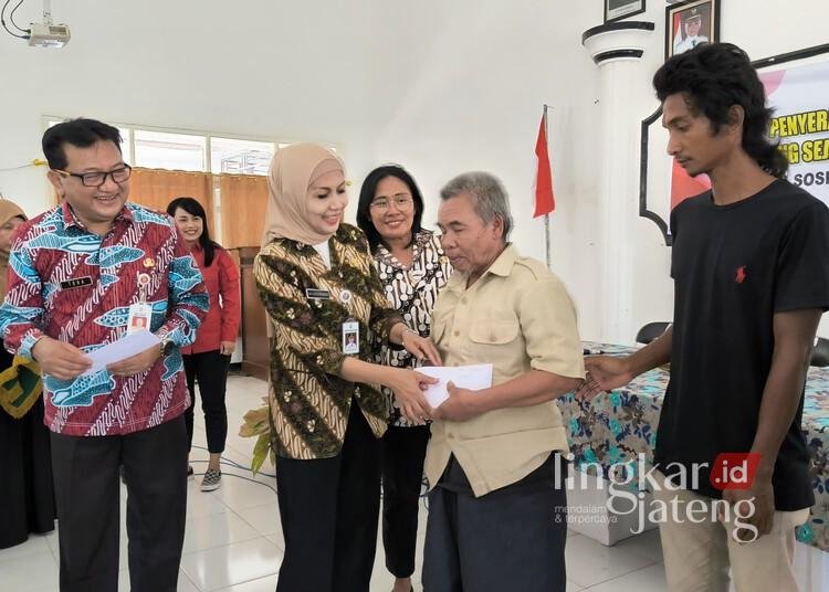 Bupati Kendal, Dyah Kartika Permanasari, didampingi Kepala Dinsos Kendal, Muntoha, secara simbolis memberikan bansos KJS tahap pertama kepada lansia dan disabilitas di Aula Kecamatan Ringinarum, Kendal, pada Kamis, 13 Maret 2025. (Arvian Maulana/Lingkarjateng.id)