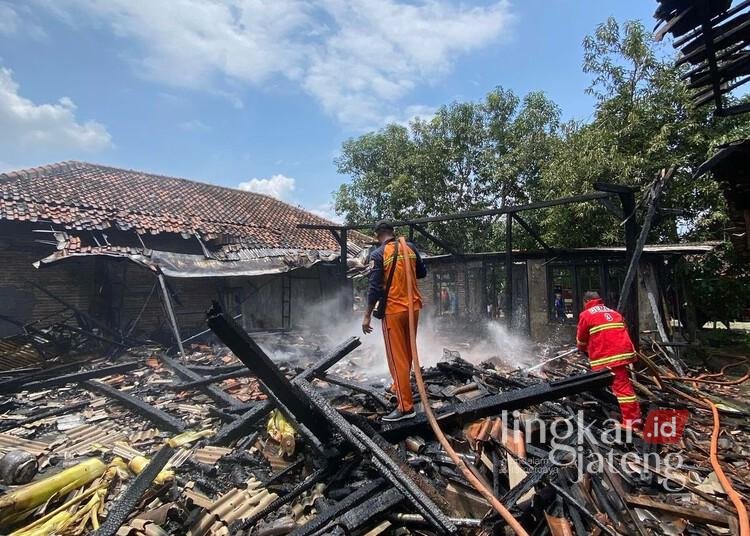 Petugas pemadam kebakaran saat melakukan proses pemadaman sisa api yang membakar rumah warga di Desa Tlogorejo, Kecamatan Karangawen, Kabupaten Demak, pada Senin, 3 Maret 2025. (M. Burhanuddin Aslam/Lingkarjateng.id)