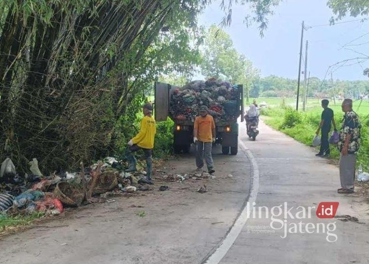 ANGKUT SAMPAH: Petugas kebersihan Dinas Lingkungan Hidup (DLH) Kabupaten Pati membersihkan sampah di pinggir jalan alternatif Pucakwangi menuju Pati kota, Selasa, 11 Maret 2025. (Lingkarjateng.id)