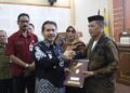 SIMBOLIS: Sekretaris Daerah (Sekda) Kabupaten Jepara Edy Sujatmiko menyerahkan surat keputusan pensiun kepada PNS yang purna tugas per 1 Maret 2025, di Gedung Shima Jepara pada Kamis, 27 Februari 2025. (Tomi Budianto/Lingkarjateng.id)