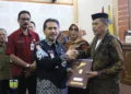 SIMBOLIS: Sekretaris Daerah (Sekda) Kabupaten Jepara Edy Sujatmiko menyerahkan surat keputusan pensiun kepada PNS yang purna tugas per 1 Maret 2025, di Gedung Shima Jepara pada Kamis, 27 Februari 2025. (Tomi Budianto/Lingkarjateng.id)