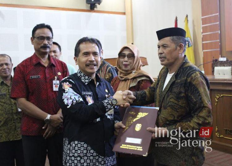 SIMBOLIS: Sekretaris Daerah (Sekda) Kabupaten Jepara Edy Sujatmiko menyerahkan surat keputusan pensiun kepada PNS yang purna tugas per 1 Maret 2025, di Gedung Shima Jepara pada Kamis, 27 Februari 2025. (Tomi Budianto/Lingkarjateng.id)