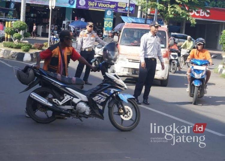 MENERTIBKAN: Petugas Dinas Perhubungan Kota Pekalongan bersama Satlantas Polres Pekalongan Kota menertibkan parkir liar di kawasan Jalan Dr. Cipto Mangunkusumo, Selasa, 11 Maret 2025 sore. (Fahri Alakbar/Lingkarjateng.id)