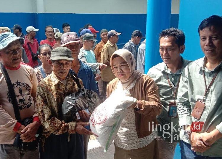 Plt Direktur Utaman PDAM Salatiga Wuri Pujiastuti menyerahkan bantuan beras kepada perwakilan tukang becak, Sabtu, 15 Maret 2025. (Angga Rosa/Lingkarjateng.id)