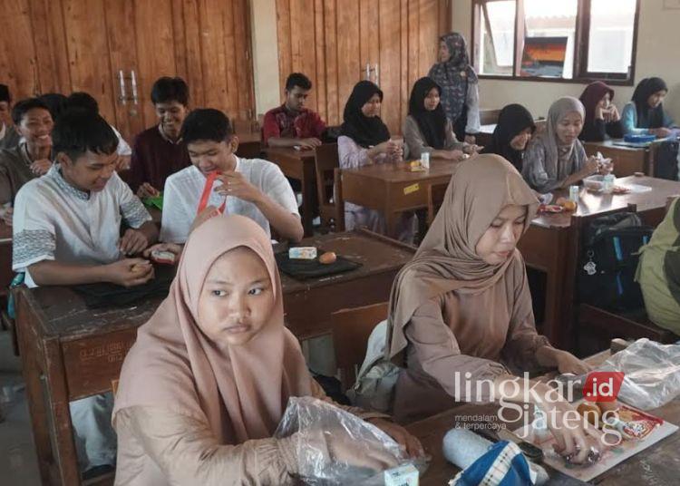 Siswa di SMA Negeri 2 Kota Pekalongan menerima paket makanan kering dari program Makan Bergizi Gratis (MBG) selama bulan Ramadhan, Jumat, 7 Maret 2025. (Fahri Akbar/Lingkarjateng.id)
