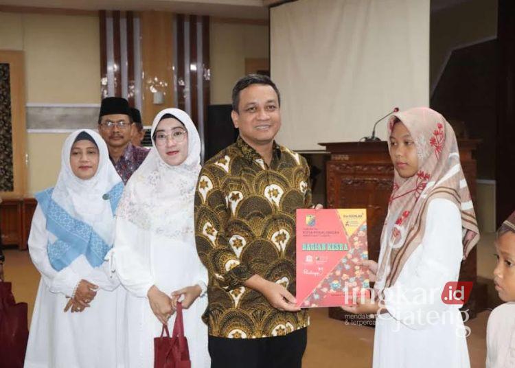 Wali Kota Pekalongan Afzan Arslan Djunaid menyerahkan santunan kepada anak yatim dalam acara yang digelar Pemkot Pekalongan dan TP PKK, Rabu petang, 19 Maret 2025. (Fahri Akbar/Lingkarjateng.id)