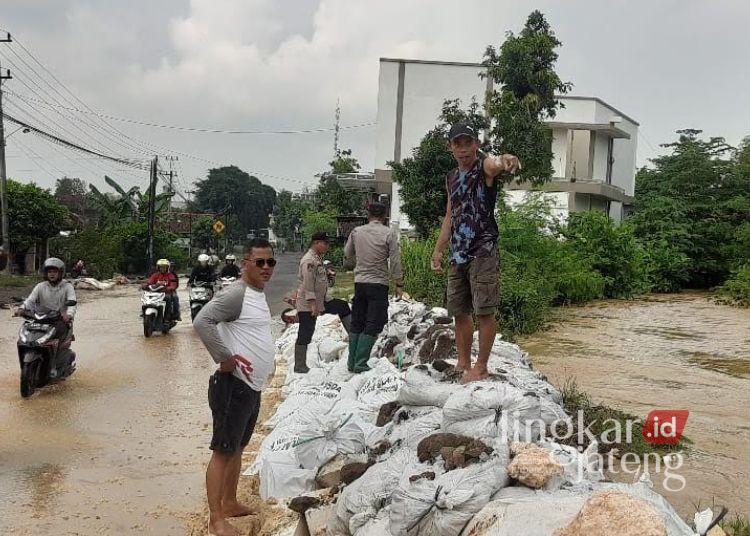 Anggota Polsek Gabus bersama warga menangani tanggul jebol di Sungai Gono, Desa Penanggungan, Kecamatan Gabus, Kabupaten Pati, Sabtu, 26 April 2025. (Setyo Nugroho/Lingkarjateng.id)