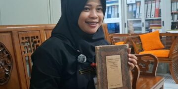 Ketua Panitia Hari Kartini, Astiana Diskha Nugraini saat memperlihatkan salah satu buku sejarah didirikanya SDN Sarirejo Kartini Kota Semarang. (Rizky Syahrul/Lingkajrjateng.id)