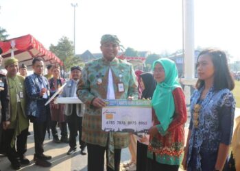 Wakil Bupati Jepara, M Ibnu Hajar yang didampingin Ketua DPRD Kabupaten Jepara, Agus Sutisna dan DPRD Provinsi Jawa Tengah, Andang Wahyu Triyanto meresmikan Kartu Guru dan Kartu Sarjana saat memperingati Hardiknas di Alun-alun 1 Jepara pada Jumat, 2 Mei 2025. (Muhammad Aminudin/Lingkarjateng.id)