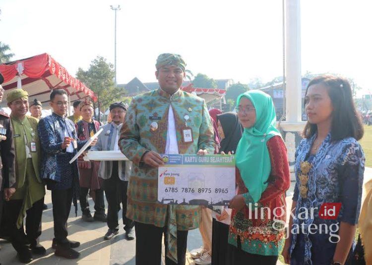 Wakil Bupati Jepara, M Ibnu Hajar yang didampingin Ketua DPRD Kabupaten Jepara, Agus Sutisna dan DPRD Provinsi Jawa Tengah, Andang Wahyu Triyanto meresmikan Kartu Guru dan Kartu Sarjana saat memperingati Hardiknas di Alun-alun 1 Jepara pada Jumat, 2 Mei 2025. (Muhammad Aminudin/Lingkarjateng.id)
