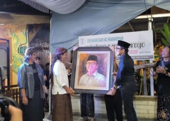 Wakil Menteri Perindustrian Faisol Riza menerima lukisan dari Gus Paox dalam kunjungannya di pagelaran seni dan pameran seni rupa dalam rangka memperingati Hari Kebangkitan Nasional 2025 yang digelar di Pondok Pesantren dan Kebudayaan Ndalem Wongsorogo di Desa Sidorejo, Kecamatan Brangsong, Kabupaten Kendal pada Selasa malam, 20 Mei 2025. (Arvian Maulana/Beritajateng.id)