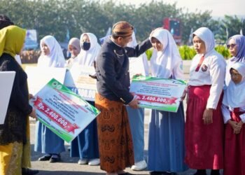 Gubernur Jateng, Ahmad Luthfi, saat menyerahkan bantuan biaya pendidikan ke sejumlah siswa dalam upacara peringatan Hardiknas Tingkat Provinsi Jawa Tengah di Alun-alun Banyumas pada Jumat, 2 Mei 2025. (Dok. Pemprov Jateng/Lingkarjateng.id)