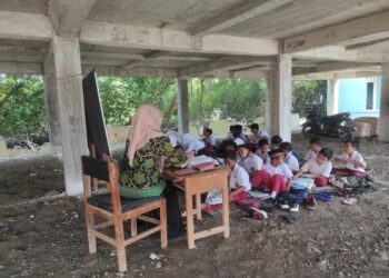 Siswa SDN 1 Bedono, Kecamatan Sayung, Kabupaten Demak, saat belajar di bawah kolong gedung baru. (M. Burhanuddin Aslam/Lingkarjateng.id)