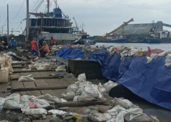 Penanganan sementara tanggul jebol di Pelabuhan Tanjung Emas, Semarang, menggunakan tumpukan karung berisi pasir, Minggu, 25 Mei 2025. (Syahril Muadz/Lingkarjateng.id)