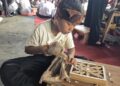 TELITI: Salah satu peserta lomba ukir dari jenjang SD sedang memahat potongan kayu untuk dijadikan hasil karya yang mempesona pada Jumat, 2 Mei 2025 di Pendopo RA Kartini Jepara. (Muhammad Aminudin/Lingkarjateng.id)