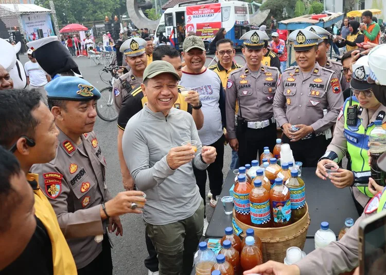 Bupati Kudus Sam'ani Intakoris mencoba jamu gratis yang disediakan Polres Kudus di CFD Alun-alun Simpang Tujuh Kudus pada Minggu pagi, 22 Juni 2025. (Mohammad Fahtur Rohman/Lingkarjateng.id)