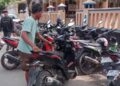 MEMARKIR: Juru parkir menata sepeda motor di lahan parkir liar depan Masjid Besar Kayen dan RSUD Kayen. (Setyo Nugroho/Lingkarjateng.id)