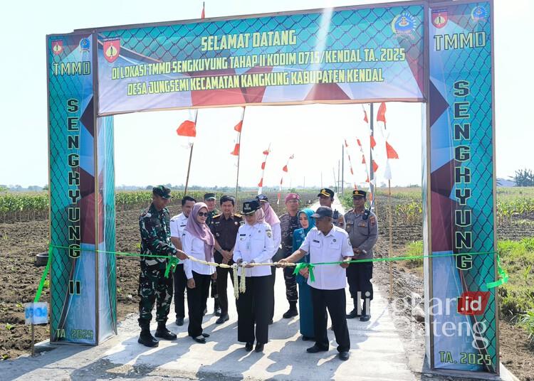 TMMD II di Jungsemi Rampung, Bupati Kendal Minta Warga Rawat Hasil Pembangunan 25 Bupati Kendal, Dyah Kartika Permanasari, didampingi Dandim 0715/Kendal saat melakukan pemotongan pita secara simbolis sebagai tanda diresmikannya jalan yang dibangun dalam program TMMD II di Desa Jungsemi, Kecamatan Kangkung, Kabupaten Kendal, pada Rabu, 4 Juni 2025. (Arvian Maulana/Lingkarjateng.id)