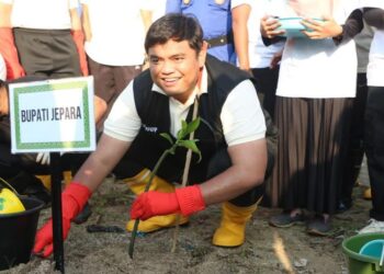 SIMBOLIS: Wakil Bupati Jepara, M. Ibnu Hajar, saat menanam bibit mangrove di Pantai Tanggultlare, Kecamatan Kedung, Kabupaten Jepara, Kamis, 5 Juni 2025. (Tomi Budianto/Lingkarjateng.id)