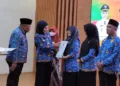 Bupati Kendal, Dyah Kartika Permansari didampingi Kepala Disdikbud Kendal memberikan penghargaan secara simbolis kepada sekolah yang berdedikasi di Gedung Abdi Praja Setda Kendal. (Arvian Maulana/Lingkarjateng.id)