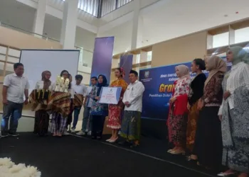 Kepala Dinas Arsip dan Perpustakaan Kabupaten Rembang, Achmad Sholchan, menyerahkan piala penghargaan kepada juara pertama duta literasi, Kamis, 26 Juli 2025. (Muhammad Faalih/Lingkarjateng.id)