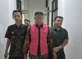 Kepala Desa Cangkring, Kecamatan Tegowanu, Kabupaten Grobogan, berinisial MA digiring oleh petugas kejari Grobogan, Jumat, 20 Juni 2025. (Ahmad Abror/Lingkarjateng.id)