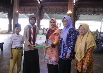 Istri Bupati Jepara, Laila Saidah Witiarso Utomo, saat menyerahkan bantuan pendidikan kepada siswa dalam Rakerda III LGNOTA Kabupaten Jepara di Pendopo Kartini pada Selasa, 17 Juni 2025. (Tomi Budianto/Lingkarjateng.id)