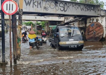 Pengguna jalan terpaksa melintasi genangan rob di Jalan KH Ahmad Dahlan, Kecamatan Tirto, Kabupaten Pekalongan, Sabtu, 31 Mei 2025. (Fahri Akbar/Lingkarjateng.id)