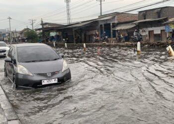 Pengendara mobil melintasi banjir rob di Jalan Pantura Demak-Semarang, Selasa, 10 Juni 2025. (M. Burhanuddin Aslam/Lingkarjateng.id)