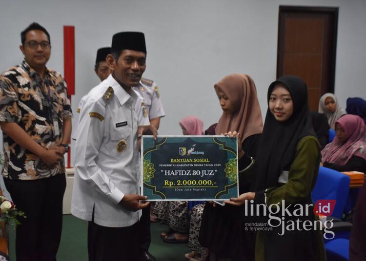 Wakil Bupati Demak, Muhammad Badruddin, menyerahkan bantuan insentif secara simbolis kepada penghafal al-quran bertempat di Ballroom Wakil Bupati Demak pada Rabu, 11 Juni 2025. (M. Burhanuddin Aslam/Lingkarjateng.id)