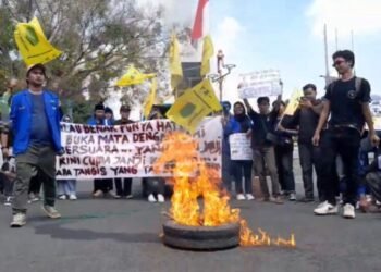 Sejumlah mahasiswa membentangkan spanduk protes dan membakar ban saat demo di depan Kantor Bupati Pati, Selasa, 3 Juni 2025. (Mutia Parasti/Lingkarjateng.id)
