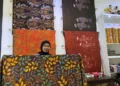 MEMAMERKAN: Pekerja di Galeri Tere Batik  memamerkan salah satu koleksi batik khas Kabupaten Kudus. (Nisa Hafizhotus Syarifa/Lingkarjateng.id)