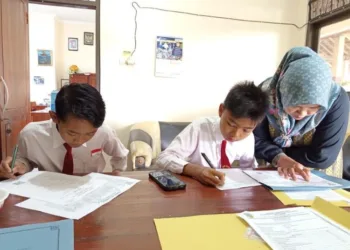 MENDAMPINGI: Guru SMP 3 Kudus mendampingi siswa yang mengisi berkas daftar ulang siswa baru tahun ajaran 2025/2026. (Fahtur Rohman/Lingkarjateng.id)