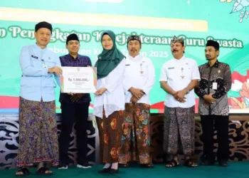 SIMBOLIS: Bupati Kudus Sam’ani Intakoris secara simbolis menyerahkan bantuan Honorarium Kesejahteraan Guru Swasta (HKGS) kepada perwakilan guru swasta di pendopo kabupaten pada Kamis, 10 Juli 2025. (Nisa Hafizhotus Syarifa/Lingkarjateng.id)