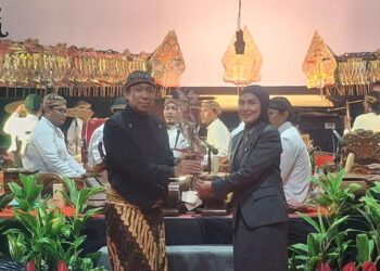 SIMBOLIS: Bupati Kendal Dyah Kartika Permanasari menyerahkan wayang tokoh Srikandi kepada dalang Ki Mangun Yuwono sebagai pembukaan pagelaran wayang kulit dalam peringatan HUT ke-420 Kabupaten Kendal pada Minggu, 27 Juli 2025. (Unggul Priambodo/Lingkarjateng.id)