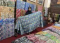 MEMAMERKAN: Karyawan Muria Batik memamerkan salah satu produk batik di Desa Karangmalang, Kecamatan Gebog, Kabupaten Kudus. (Nisa Hafizhotus Syarifa/Lingkarjateng.id)