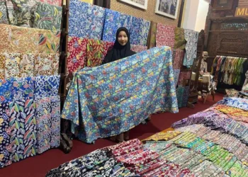 MEMAMERKAN: Karyawan Muria Batik memamerkan salah satu produk batik di Desa Karangmalang, Kecamatan Gebog, Kabupaten Kudus. (Nisa Hafizhotus Syarifa/Lingkarjateng.id)