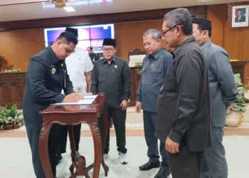 Bupati Jepara, Witiarso Utomo, saat menandatangani Perda Perubahan APBD 2025 di hadapan pimpinan DPRD Jepara dalam rapat paripurna pada Rabu, 9 Juli 2025. (Tomi Budianto/Lingkarjateng.id)