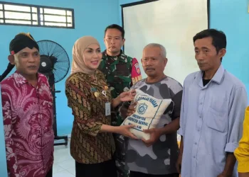 Bupati Kendal, Dyah Kartika Permanasari, menyerahkan bantuan beras kepada warga terdampak rob di Desa Kartika Jaya, Kecamatan Patebon, Kabupaten Kendal, pada Selasa, 1 Juli 2025. (Arvian Maulana/Lingkarjateng.id)