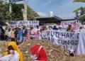 Ratusan warga Desa Tanjungrejo, Kecamatan Margoyoso, Kabupaten Pati, memblokade pintu masuk Pabrik Surya Jaya Beton (SJB) pada Rabu, 23 Juli 2025. (Mutia Parasti/Lingkarjateng.id)
