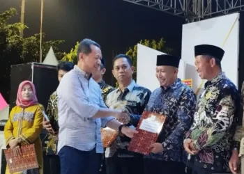 Bupati Kudus, Sam'ani Intakoris, berjabat tangan dengan Kepala Desa Berugenjang, Kiswo, saat ekspo UMKM di Alun-alun Kudus, Minggu, 6 Juli 2025. (ANTARA/Lingkarjateng.id)