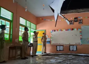 Plt Kepala SDN Kawengen 02 dan para guru saat menunjukkan atap ruang kelas yang rusak. (Hesty Imaniar/Lingkarjateng.id)