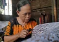 MEMBATIK: Perajin batik Lasem, Kabupaten Rembang sedang membuat pola. (Humas Pemkab Rembang/Lingkarjateng.id)