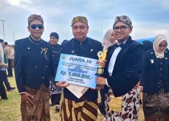 Bupati Batang, M. Faiz Kurniawan (kanan), menunjukkan piala lomba pemeliharaan jaringan irigasi tingkat Jawa Tengah yang diterima Kabupaten Batang usai upacara di Lapangan KEK Industropolis, Selasa, 19 Agustus 2025. (Pemkab Batang/Lingkarjateng.id)