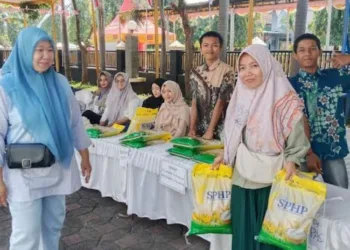 BELANJA: Seorang warga usai berbelanja sembako di bazar pangan murah yang digelar di halaman kantor Disperindag Kabupaten Pekalongan, Rabu, 27 Agustus 2025. (Fahri Akbar/Lingkarjateng.id)