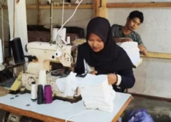 Buruh jahit di Desa Coprayan, Kecamatan Buaran, Kabupaten Pekalongan Ulfa bersama suaminya, Ismanto, mengerjakan pesanan. (WA Group/Lingkarjateng.id)