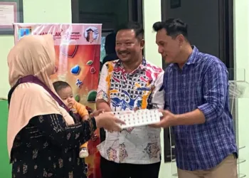 SIMBOLIS: Seorang warga Kelurahan Sunggingan, Kecamatan Kota, Kabupaten Kudus menerima bantuan telur sebagai upaya mencegah stunting. (Nisa Hafizhotus Syarifa/Lingkarjateng.id)